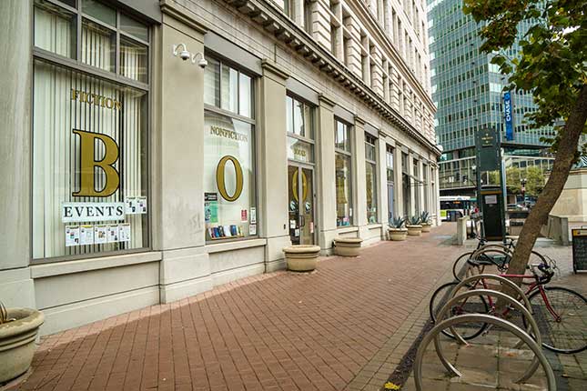 Gray stone and large windows frame the front of Laurel Book Store in Oakland, California