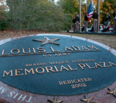 The plaque at the Louis L Adam Memorial Plaza in College Station, TX.
