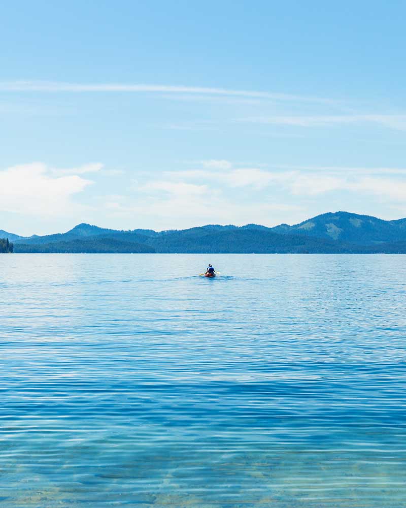 people sit in a canoe between two docks at Priest Lake State Park