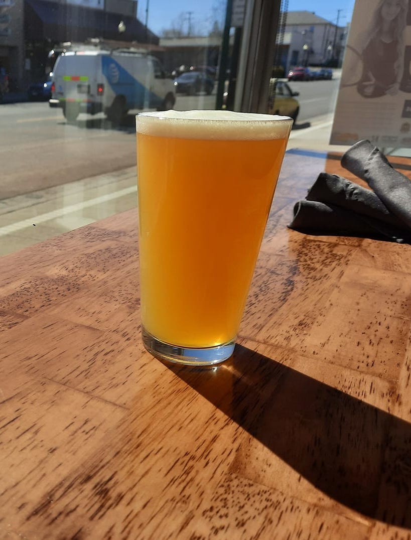 a pint of beer near a window 